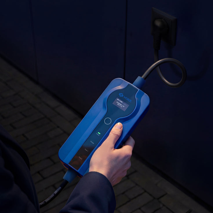 Hand holding the control box of the Voldt® Type 1 Portable Charger at night